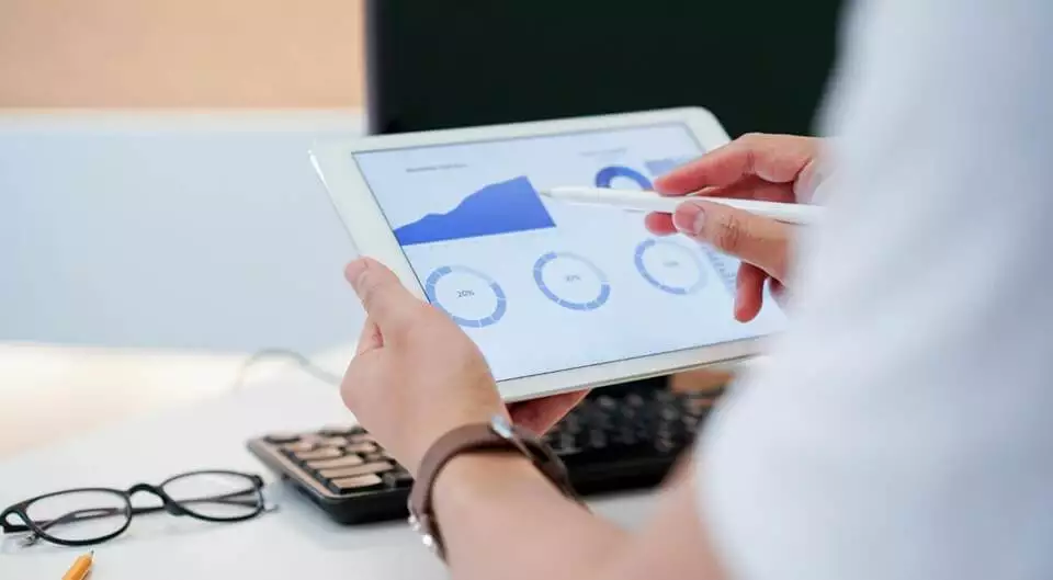 A person using an iPad to analyze a graph on Things That Make Your Website Convert.