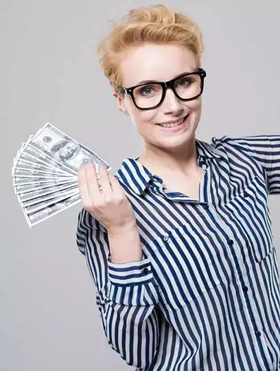 a smiling woman with short blonde hair and glasses, wearing a striped shirt, holding a fan of dollar bills in her hand against a gray background, representing "maximize your income.