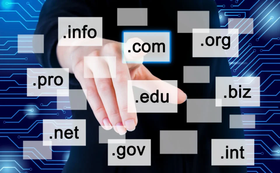 a hand points to a holographic display of various domain extensions like .com, .org, .edu, and more against a technological background, emphasizing the ease of domain registrations and domain renewals with namecheap.