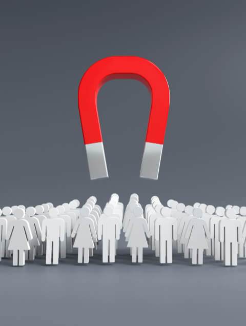 a large red horseshoe magnet hovering above a crowd of white silhouetted figures representing lead generation on a gray background.