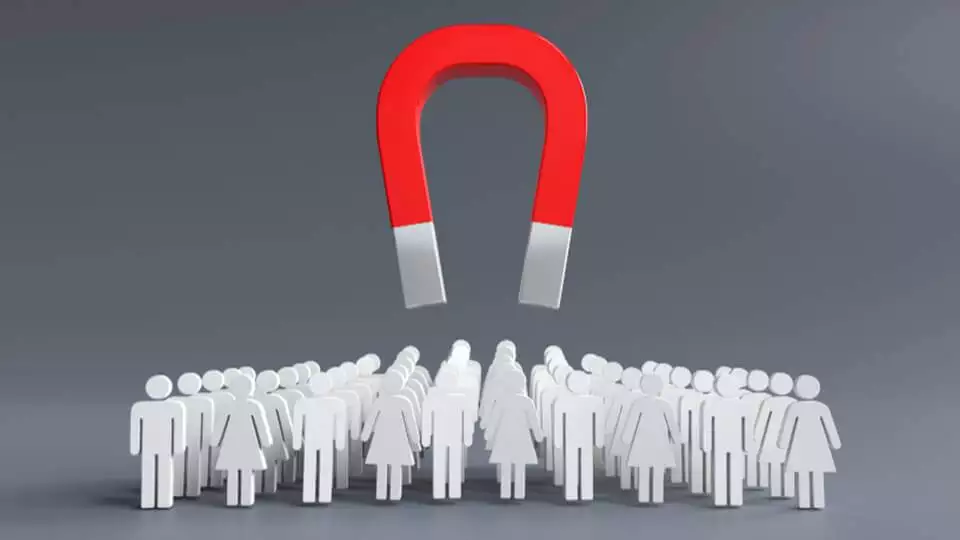 a large red horseshoe magnet levitating above a group of white figures on a gray background, symbolizing lead generation or influence.