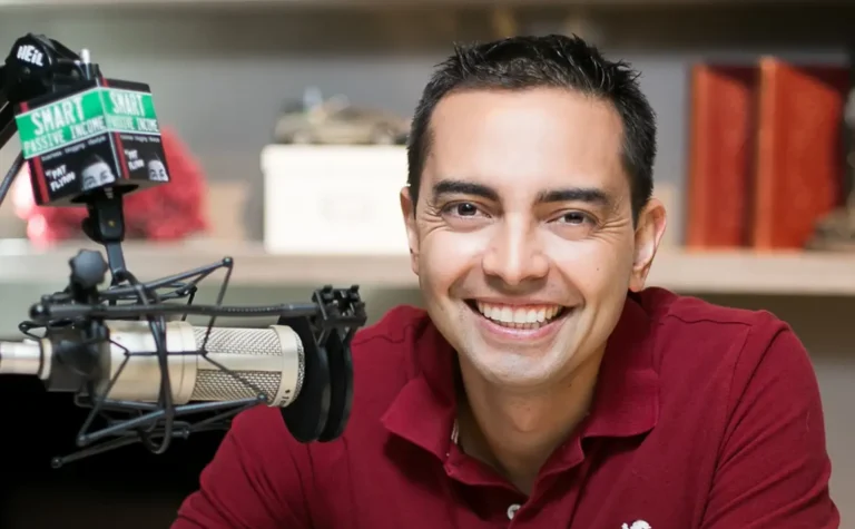 Pat Flynn in a red shirt sits near a microphone labeled "smart passive income," embodying hiss approach to building your business.