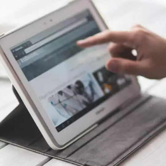 a hand pointing at a tablet, demonstrating effective strategies for increasing sales on instagram and facebook.