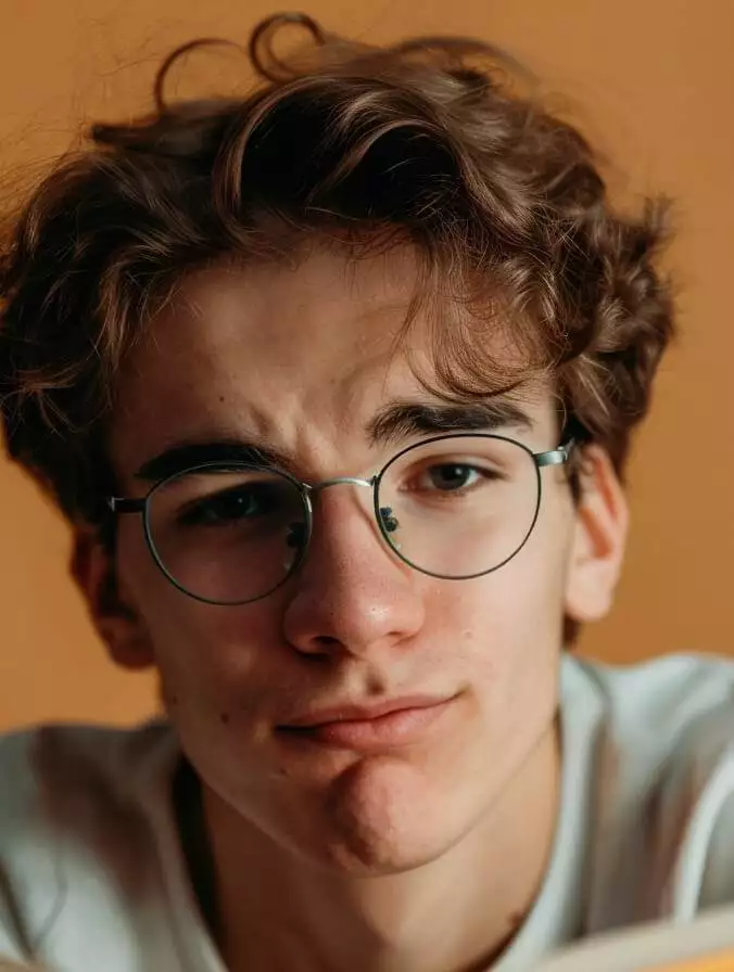 a young man with glasses reading a book on website conversion mistakes.